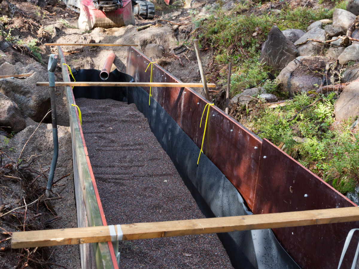 leach field installation process with piping, digging, and metal barriers
