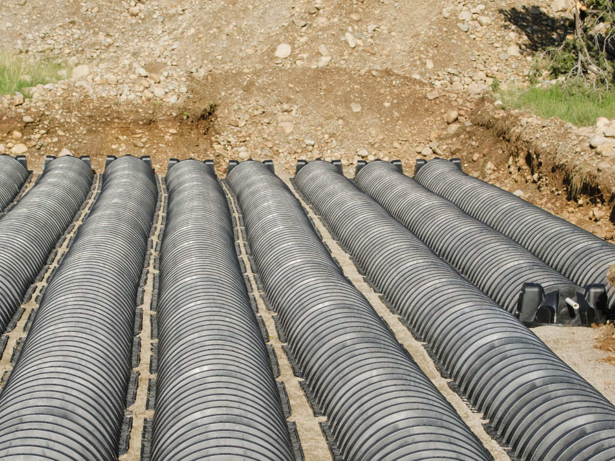 newly installed leach field with black piping in ground