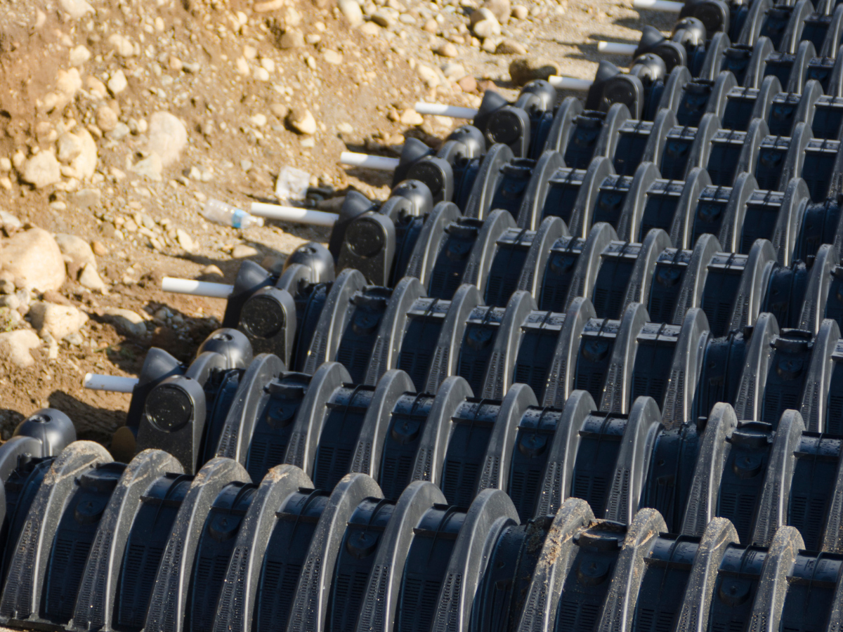black leach field piping in ground, close-up